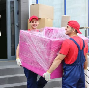Zwei Umzugshelfer tragen ein in Folie gepacktes Möbelstück – Umzug in Sinsheim