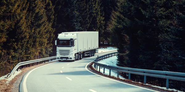 Klaviertransport Sinsheim: Lkw fährt auf einer kurvigen Straße durch den Wald