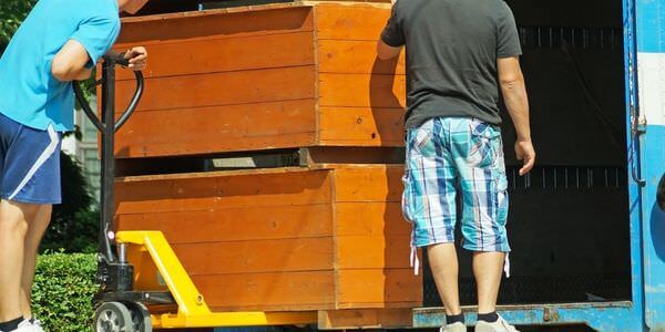 Möbellift Sinsheim: Zwei Helfer tragen einen Holzschrank aus einem Lkw